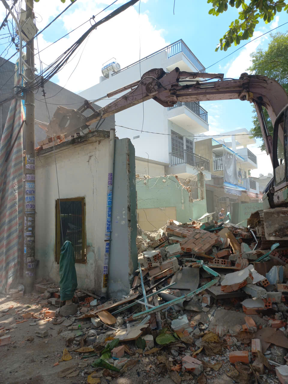 Máy múc tháo dỡ nhà cũ trong hẻm nhỏ